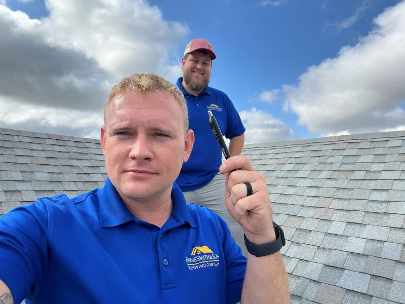 Sam on a shingle roof during an inspection